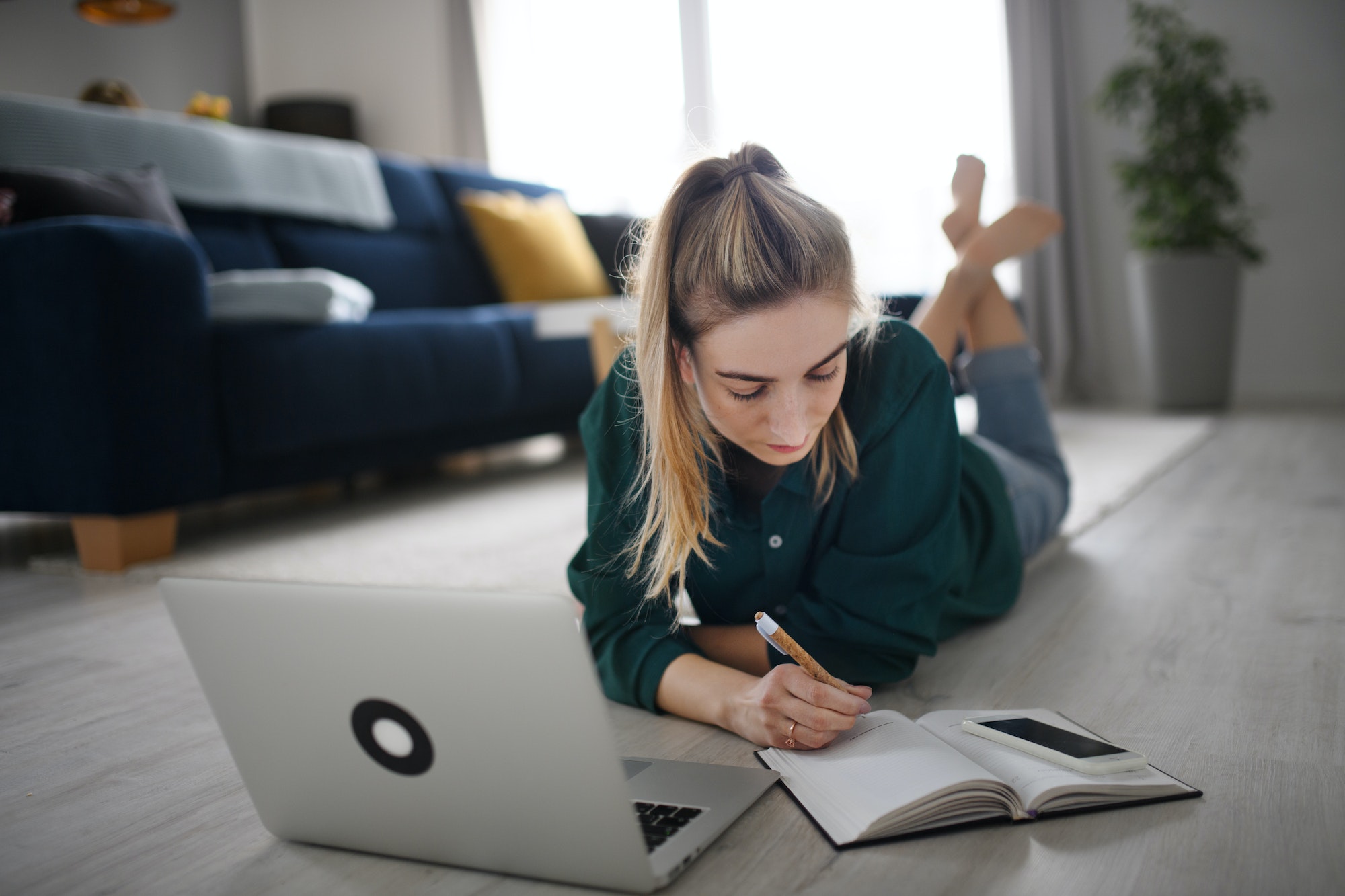 Young woman student with laptop and smartphone at home, home office and learning